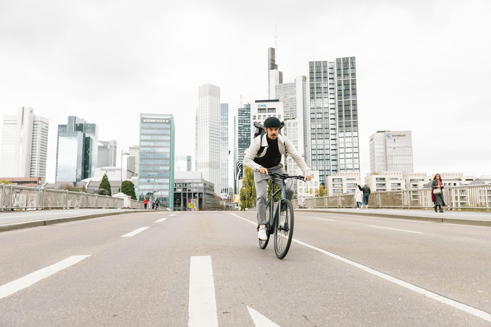 Mann fährt auf leichtem Fitness-E-Bike Sydney über eine Brücke